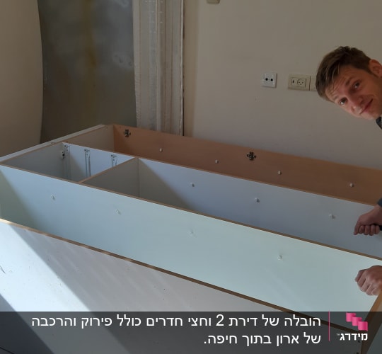 אדם מרכיב רהיט בעזרת מברג בחדר